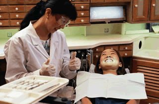 Dental hygienist performing an oral hygiene procedure on a pediatric patient